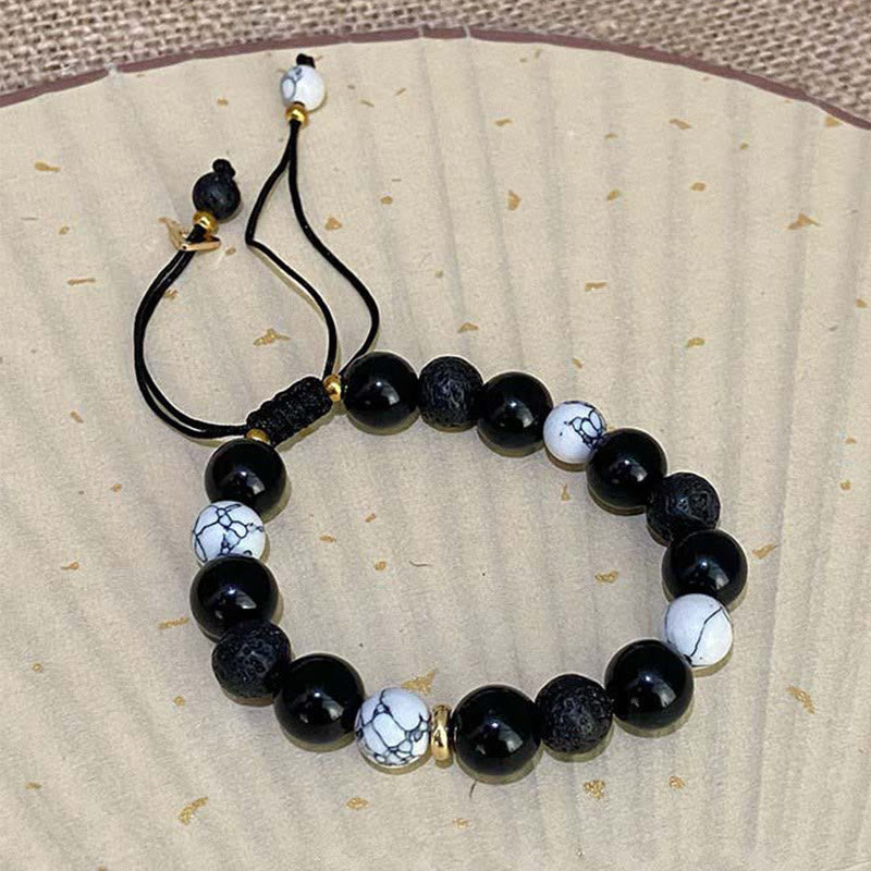 Black Obsidian Lava Rock Yin Yang Bracelet – Adjustable black cord bracelet on gold-flecked paper, unisex natural stone be...