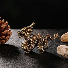 Auspicious Brass Dragon Decoration - Serpentine brass dragon on dark fabric, dramatic studio lighting, feng shui decor
