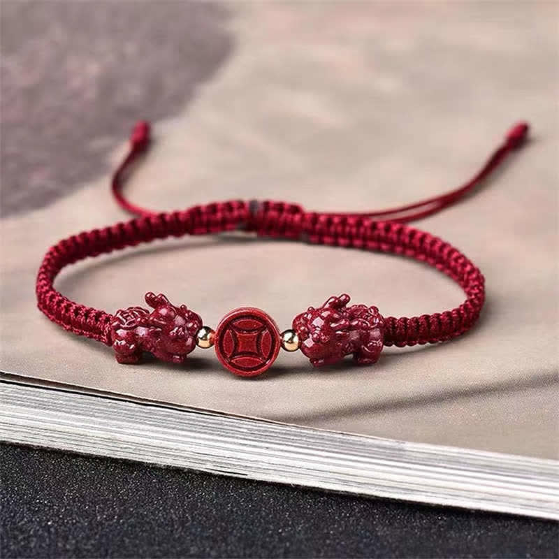 Cinnabar PiXiu Copper Coin Red String Bracelet – Red braided bracelet with cinnabar PiXiu charms on beige paper
