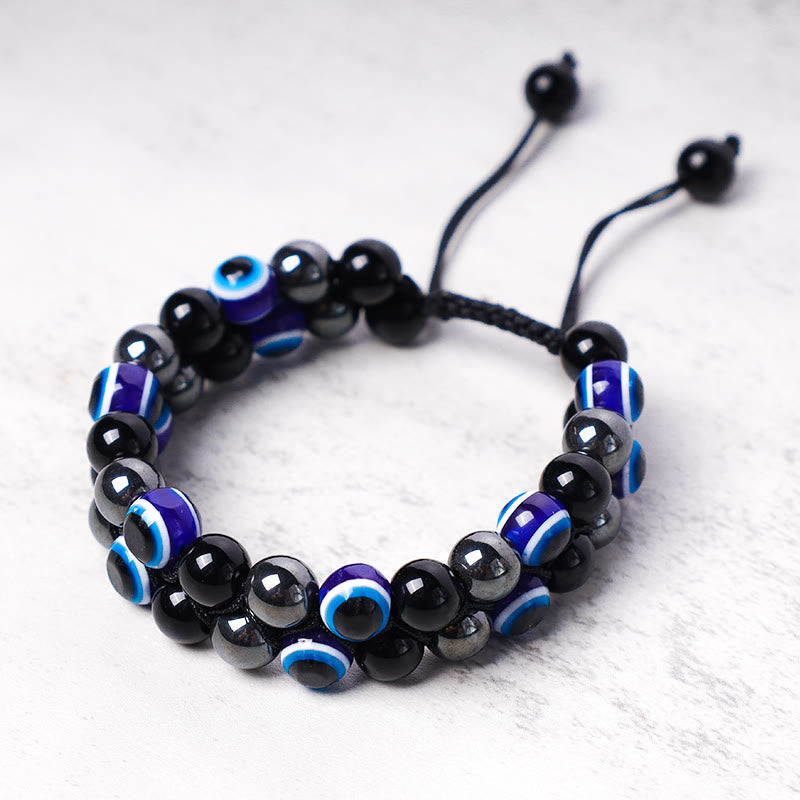 Evil Eye Hematite Tiger Eye Bracelet – hematite silver-gray beads with blue nazar beads on stone surface
