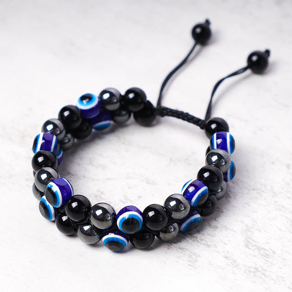 Evil Eye Hematite Tiger Eye Bracelet – hematite silver-gray beads with blue nazar beads on stone surface