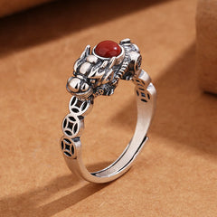PiXiu Copper Coin Red Agate Ring three-quarter view on kraft paper, silver beast motif, adjustable band, luck
