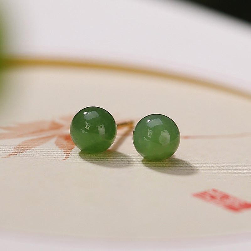 925 Silver Cyan Jade Healing Stud Earrings – apple green jade bead pair on cream textured rice paper with coral brushstrokes, artistic flat lay