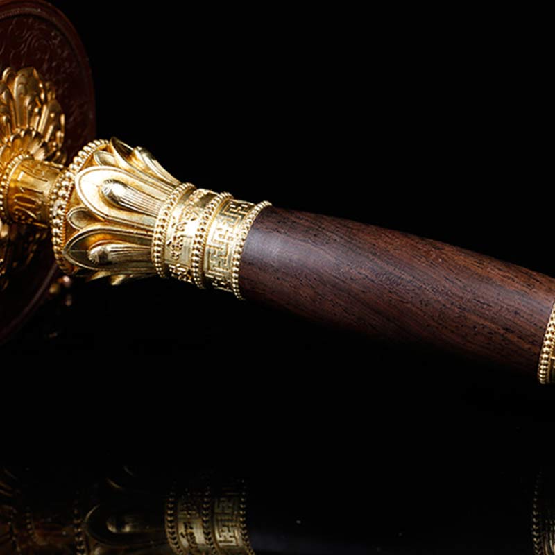 Copper Prayer Wheel – Macro detail of gold metal collar on dark wood handle, artisan craft