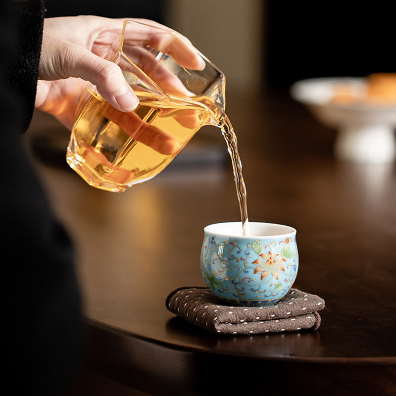 Lotus Pod Ceramic Tea Cup – amber tea poured into blue lotus cup, tea ceremony