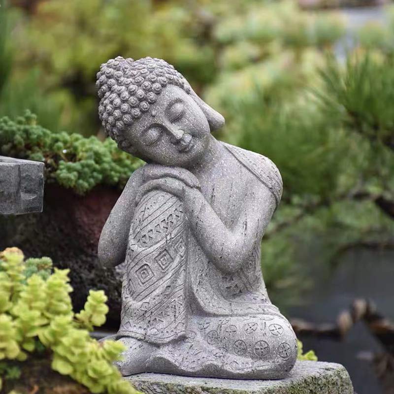 Tibetan Meditation Buddha Resin Decoration – resting Buddha statue in garden setting with lush greenery, stone-texture resin, outdoor Zen decor