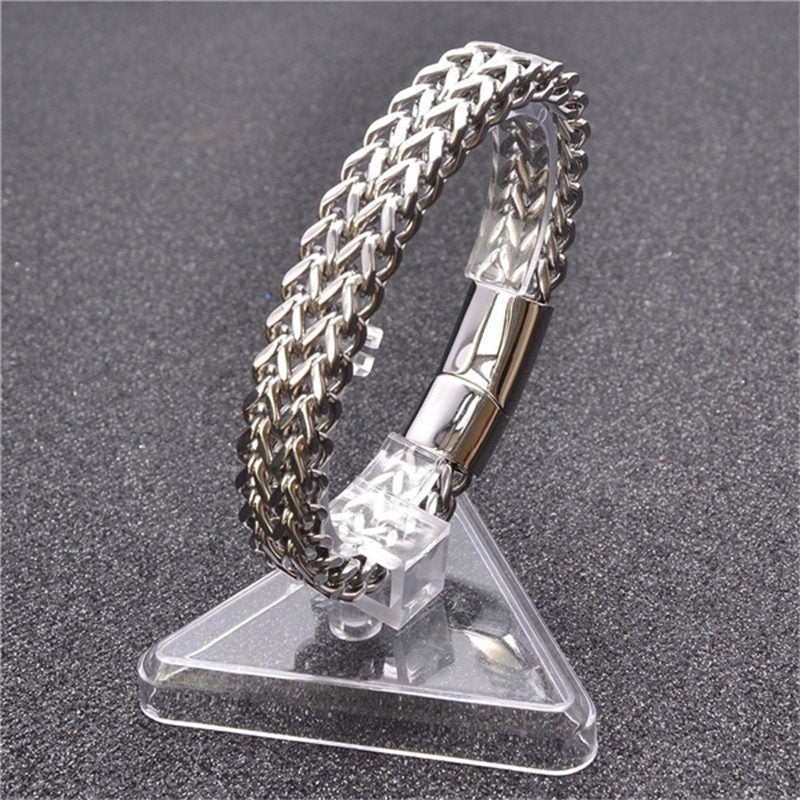 Fish Scale Titanium Steel Magnetic Bracelet – silver chain on clear acrylic triangle stand, dark textured backdrop, three-quarter view