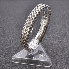 Fish Scale Titanium Steel Magnetic Bracelet – silver chain on clear acrylic triangle stand, dark textured backdrop, three-quarter view