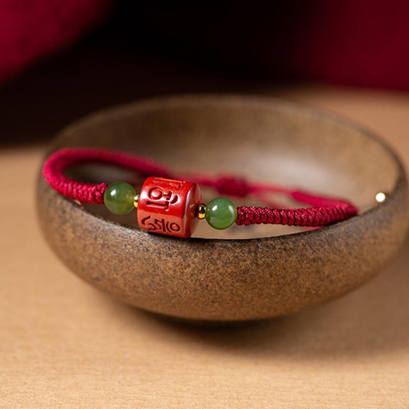 Tibetan Cinnabar Braided Rope Bracelet – Resting in rustic ceramic bowl, carved red bead focal point