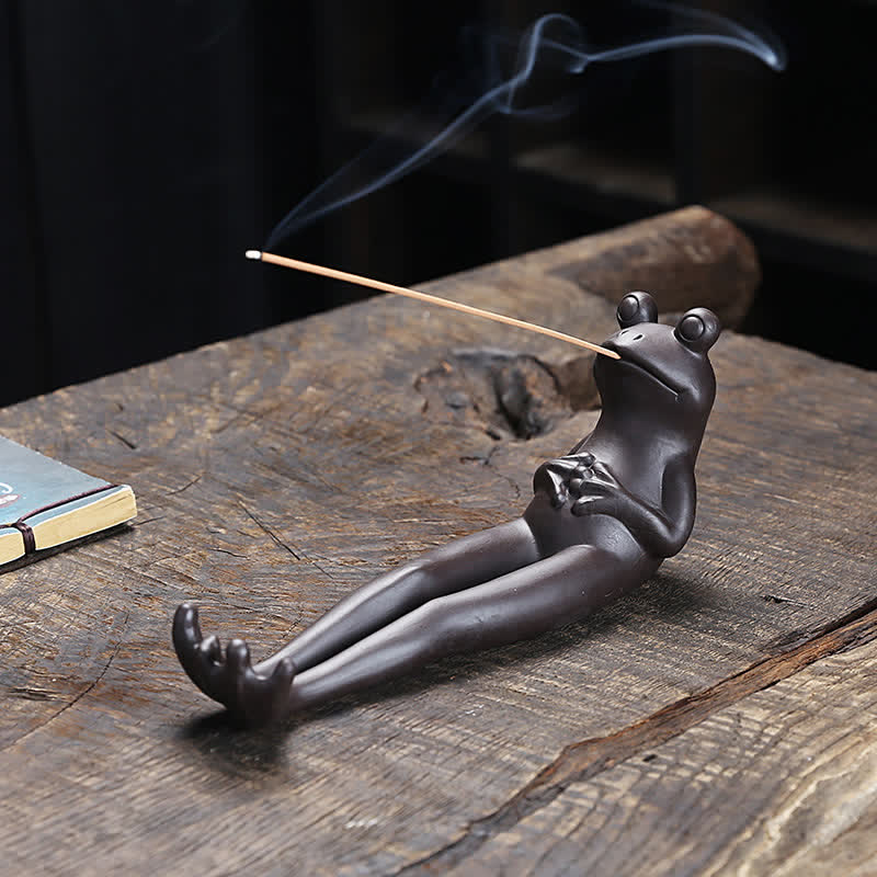 Meditation Frog Ceramic Incense Burner - Dark reclining frog with smoke on weathered wood, zen incense holder