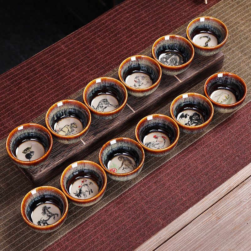 12 Zodiac Jian Zhan Teacup - four cups overhead showing Rat Ox Rabbit Tiger zodiac paintings on cream medallion interiors