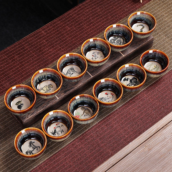12 Zodiac Jian Zhan Teacup - four cups overhead showing Rat Ox Rabbit Tiger zodiac paintings on cream medallion interiors