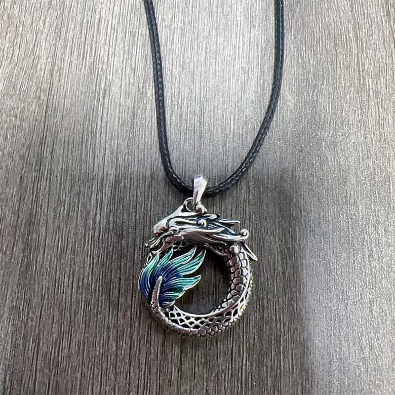 Tibetan Copper Dragon Necklace - Overhead on wood grain, teal enamel dragon ring, Healing