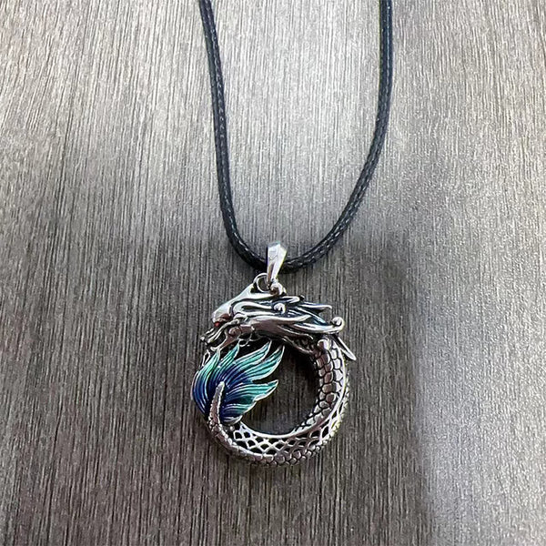 Tibetan Copper Dragon Necklace - Overhead on wood grain, teal enamel dragon ring, Healing