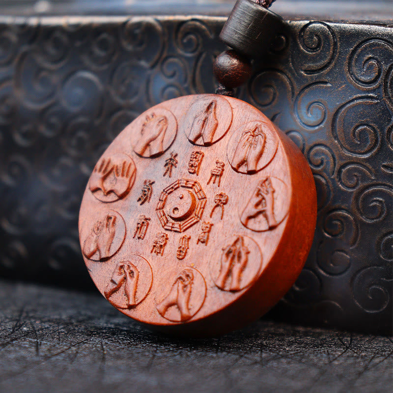 Lightning Struck Jujube Wood Pendant – Circular sandalwood disc with central bagua yin-yang symbol, eight carved mudra hand g
