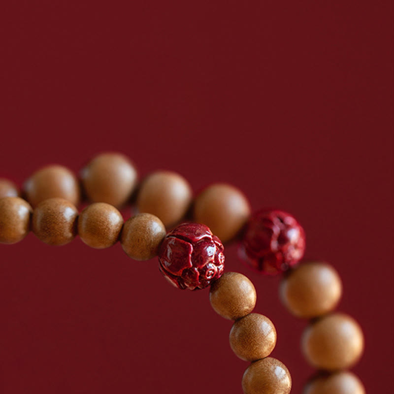 Peach Wood & Cinnabar Lotus Bracelet macro detail, carved cinnabar lotus bead with sandalwood prayer beads, zen style