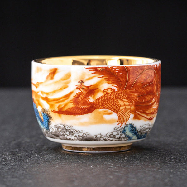 Dragon Phoenix Crane Gilt Ceramic Teacup – hand-painted red phoenix with golden clouds and cobalt blue wave base, gold interior, ceremonial