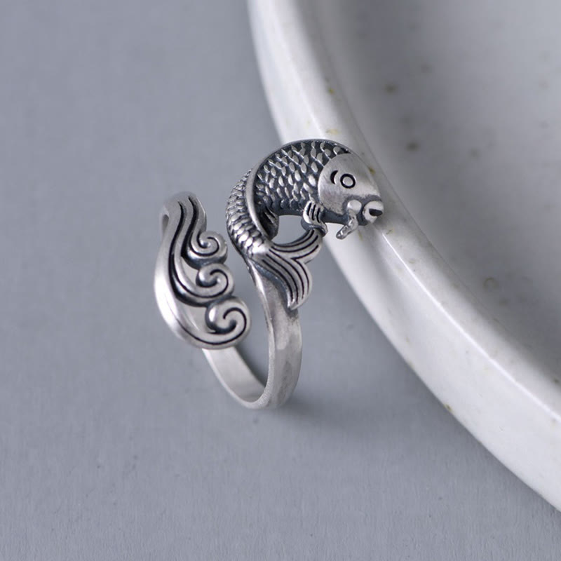 925 Sterling Silver Koi Ring – flat lay on white marble, silver koi swimming through engraved waves, wealth amulet