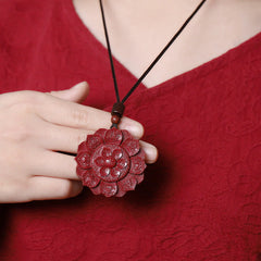 Cinnabar Om Mani Padme Hum Lotus Necklace – carved red pendant worn against crimson garment, om