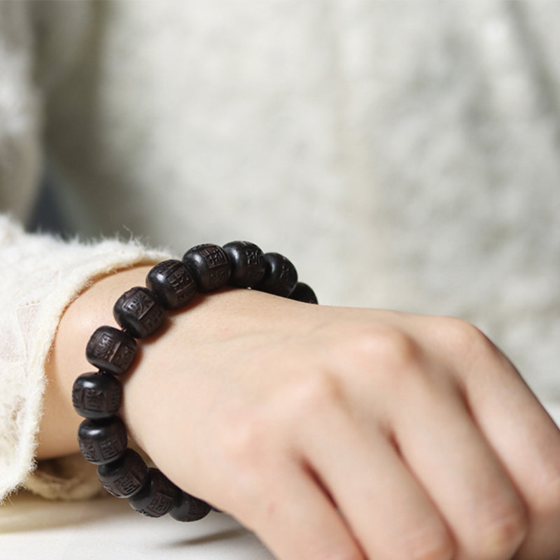 Ebony Wood Mantra Bracelet – Profile view on wrist against soft blurred background, beaded wristband