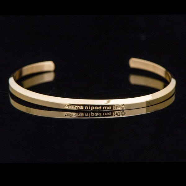 Om Mani Padme Hum Engraved Bracelet – gold cuff with mantra text on black background, spiritual bangle