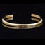 Om Mani Padme Hum Engraved Bracelet – gold cuff with mantra text on black background, spiritual bangle