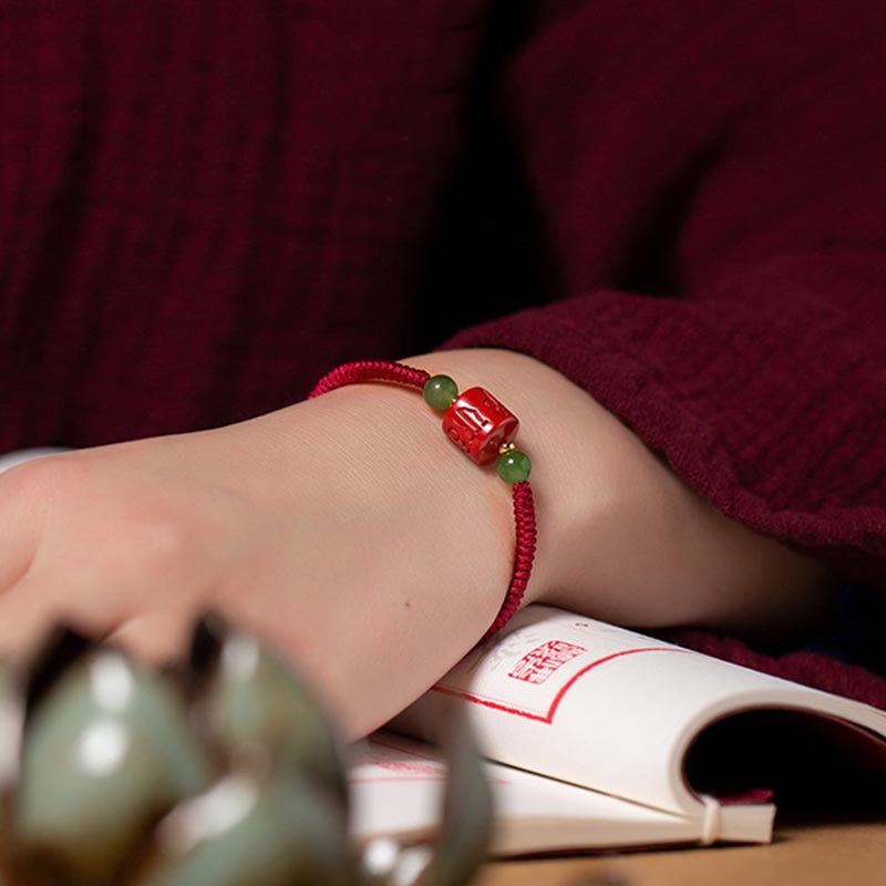Tibetan Cinnabar Braided Rope Bracelet – Worn on wrist beside Chinese calligraphy book, cultural styling