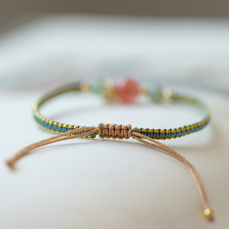 Red Agate Jade Lotus Bracelet – teal gold braided cord with adjustable tan sliding knot, pink green beads in soft bokeh background