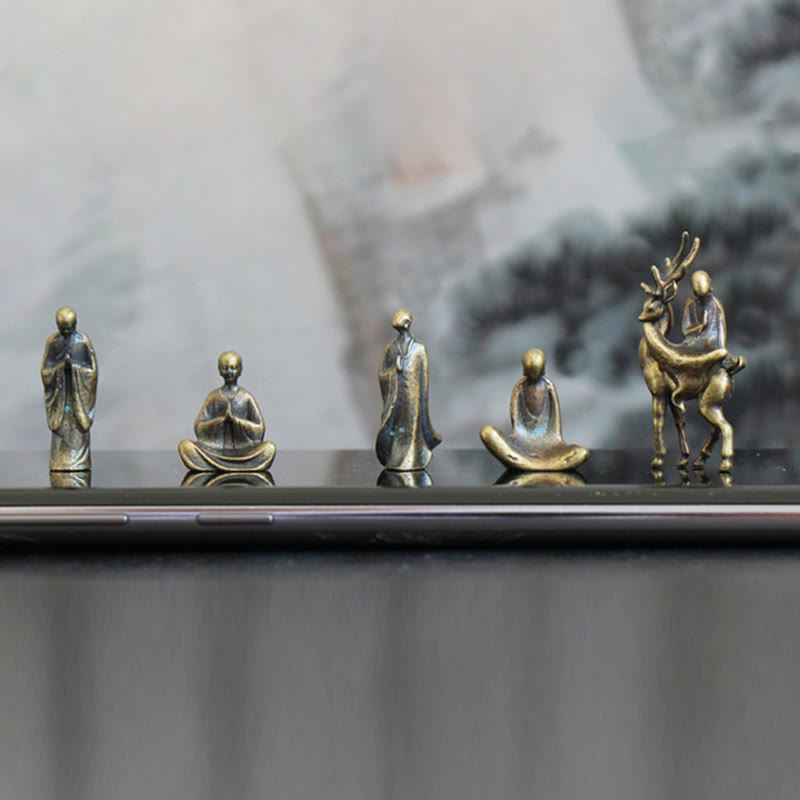 Mini Metal Meditation Buddha Decoration – monks and deer figure on reflective black surface with landscape art, contemplation