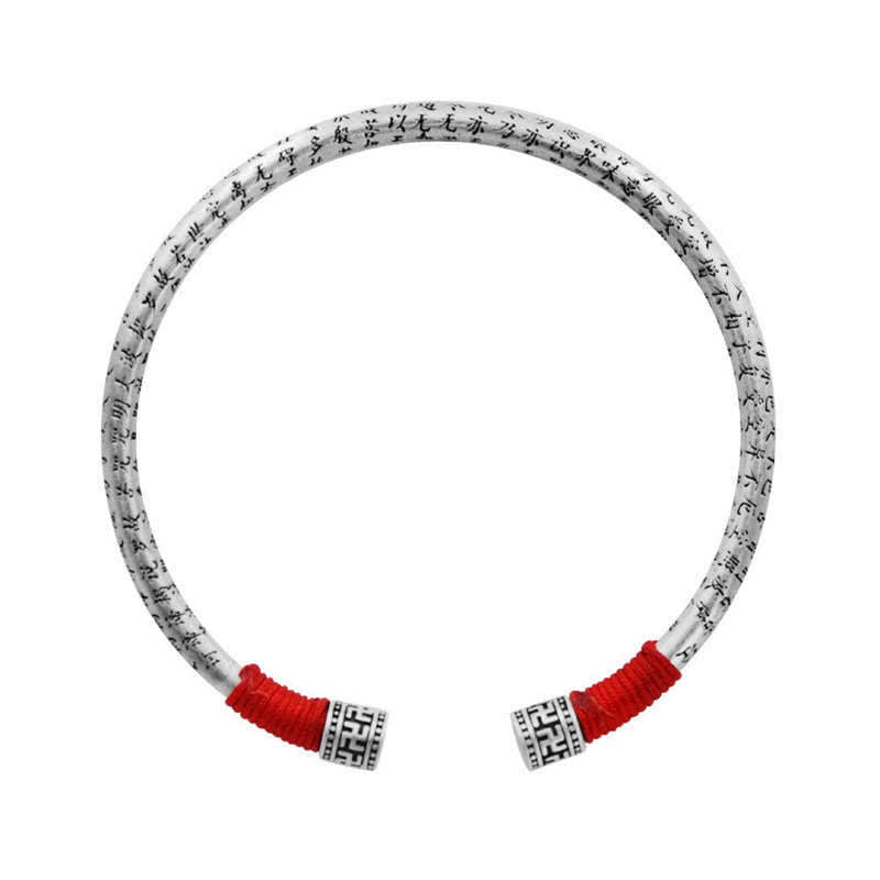 Tibetan Red String Bracelet – top-down white background, silver cuff with black calligraphy engraving