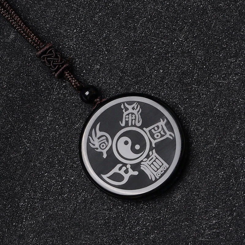 Black Obsidian Nine-Character Mantra Necklace – Carved Yin-Yang obsidian amulet, dark textured background, stone pendant