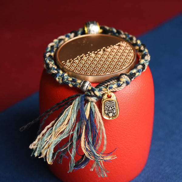 Zakiram Goddess Bracelet – Multi-color braided cord on red stand with gold tribal pendant, handmade bracelet