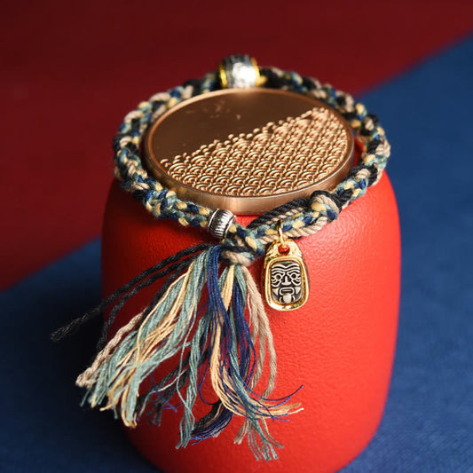 Zakiram Goddess Bracelet – Multi-color braided cord on red stand with gold tribal pendant, handmade bracelet