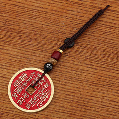 Shan Gui Keychain – red enamel amulet with ancient script on wood grain surface, top-down view