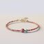 Rhodonite Loving Energy Bracelet – Pink bead bracelet with larger rose focal bead, turquoise accent and gold spacers on white background low side angle