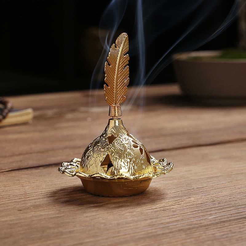 Mini Alloy Incense Burner – gold censer with detailed feather finial, smoke rising on wooden table