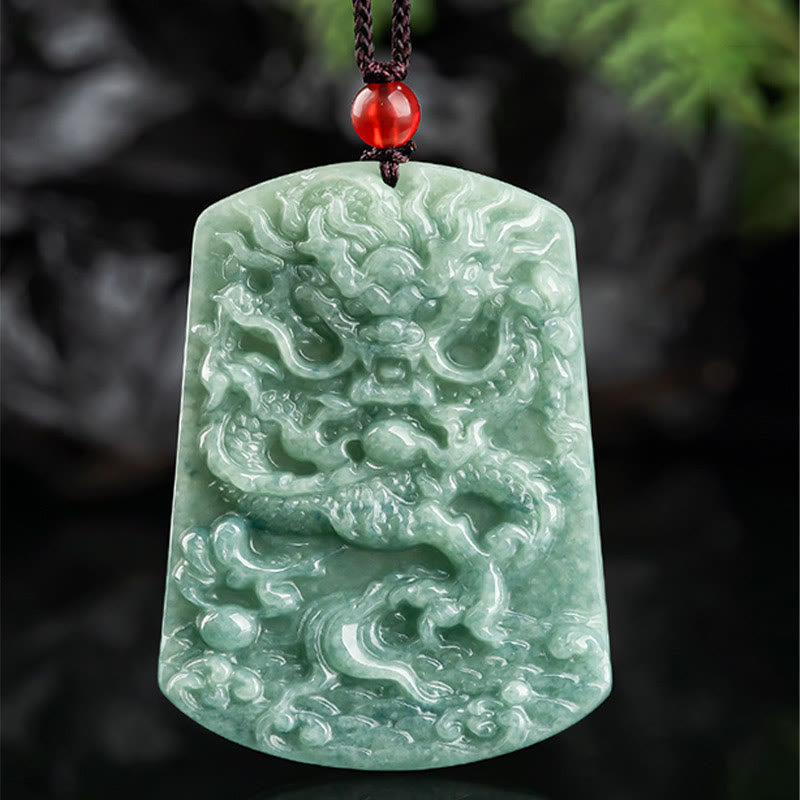 Natural Jade Dragon Pendant – Mottled jade dragon pendant on wet dark stone with red accent bead, Natural texture