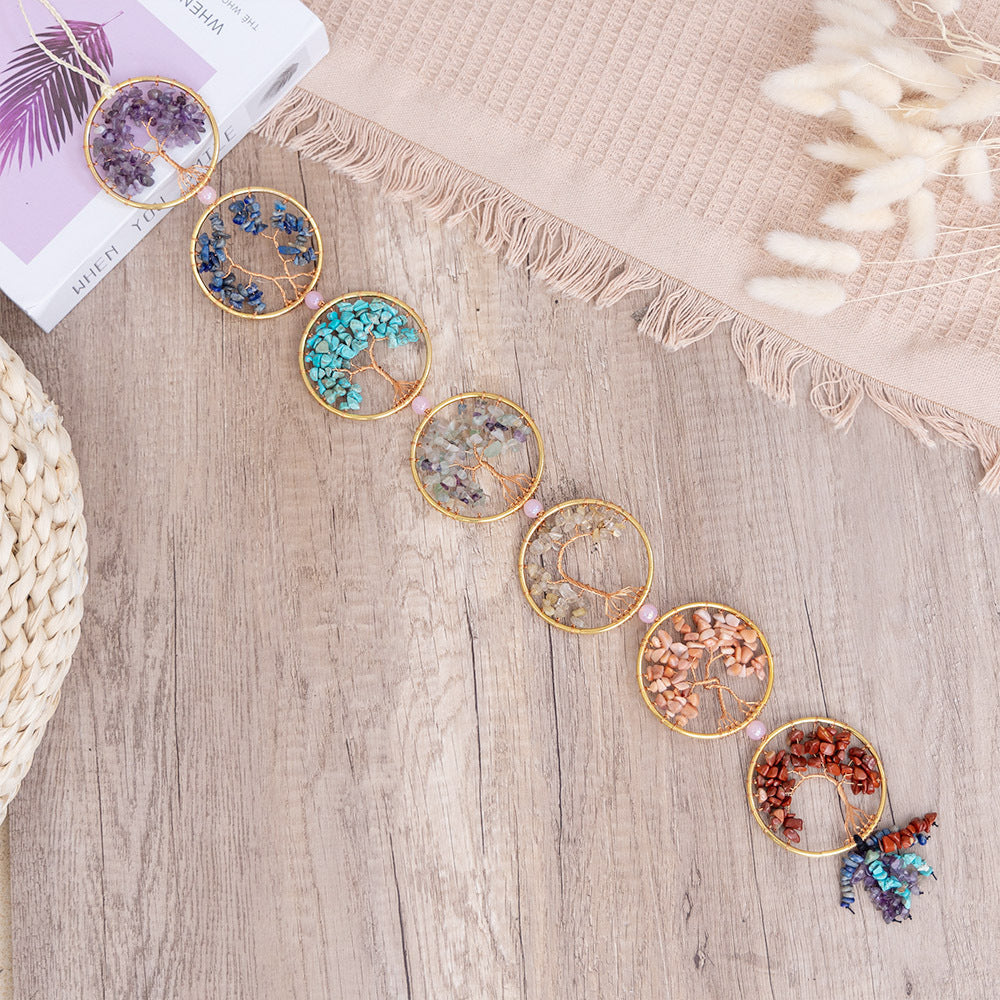 Chakra Tree of Life – seven crystal tree circles laid flat on wooden table, chakra healing stones