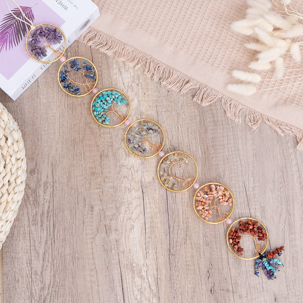 Chakra Tree of Life – seven crystal tree circles laid flat on wooden table, chakra healing stones