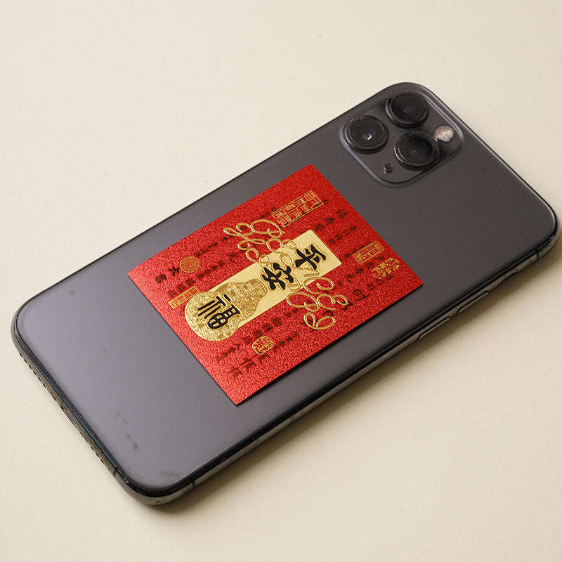Red peace blessing gold sticker applied on black smartphone back
