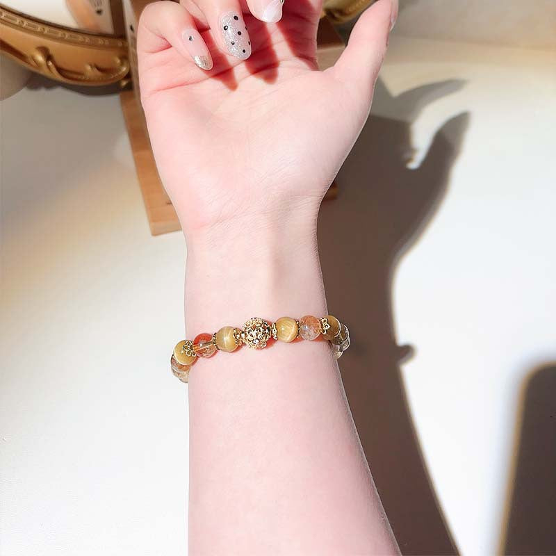Natural Citrine Bracelet – golden yellow and clear citrine beads with gold filigree spacer beads worn on a woman's wrist, warm toned vanity table background with mirror, lifestyle try-on shot