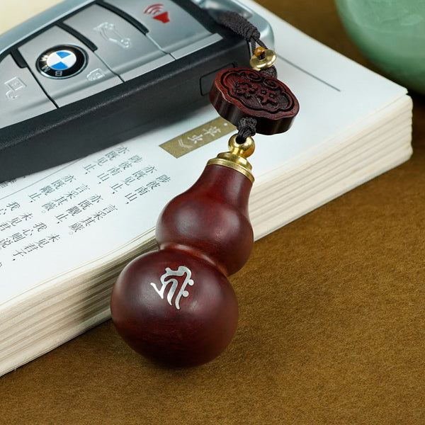 Red sandalwood gourd keychain attached to car key fob for everyday protection