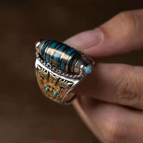 Dzi Bead Prayer Wheel Ring – fingers holding ring showing blue striped dzi barrel and turquoise dots