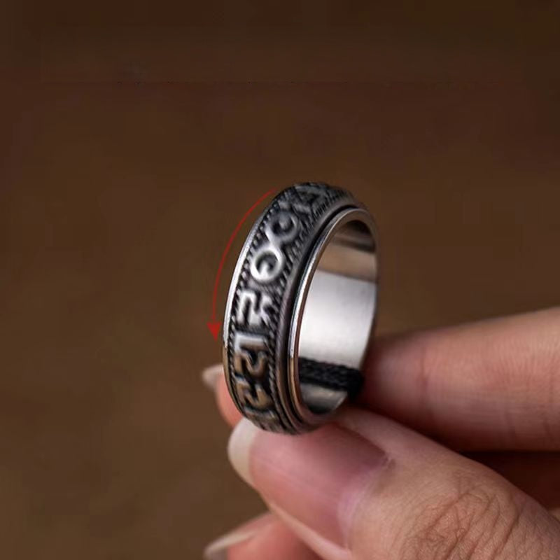 Mantra Phone Ring – close-up of spinning band with mantra characters held between fingertips