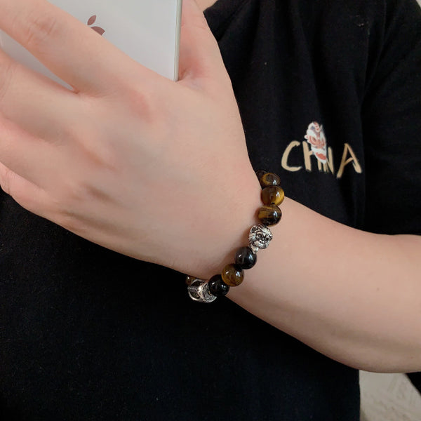 Tiger Eye Bracelet – Bracelet on wrist with black shirt, hand holding phone, everyday protection jewelry