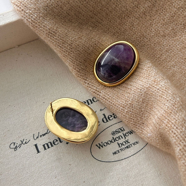 Amethyst Stud Earrings – reverse side of gold bezel amethyst stud showing ear post on cream canvas with brown knit scarf, 925 silver post