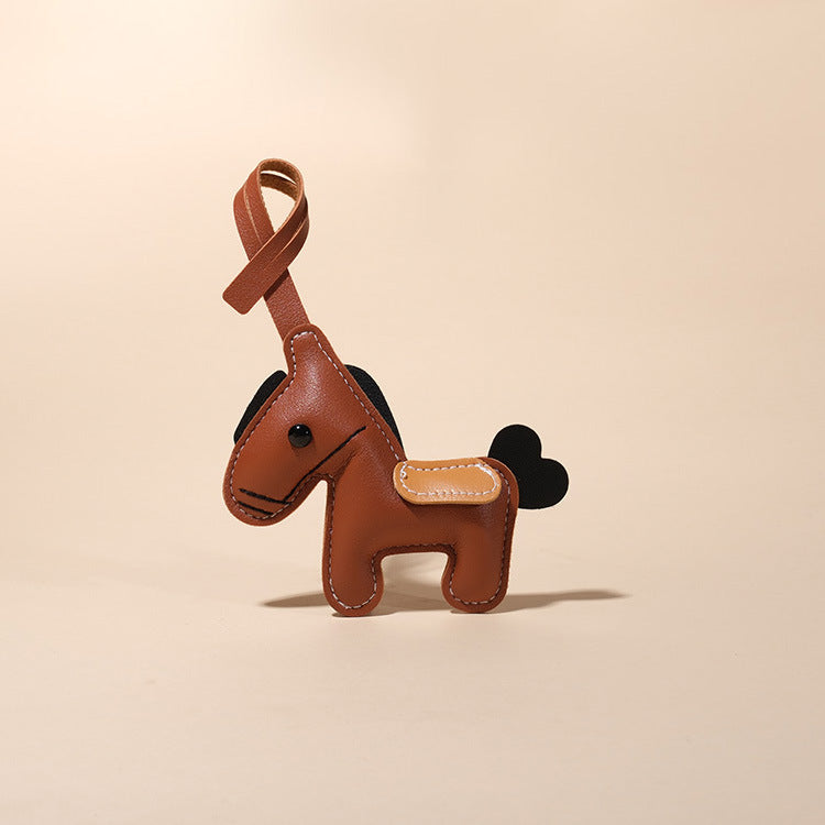 Feng Shui Leather Horse Keychain – Brown PU leather horse on beige background, feng shui accessory