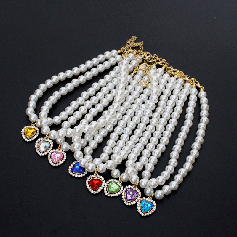 Crystal Heart Pet Necklace – Seven colorful heart pendant pearl collars fanned on black background