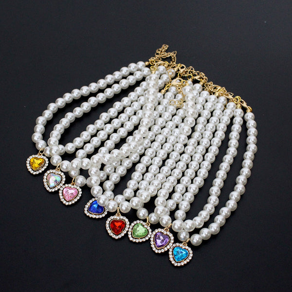 Crystal Heart Pet Necklace – Seven colorful heart pendant pearl collars fanned on black background