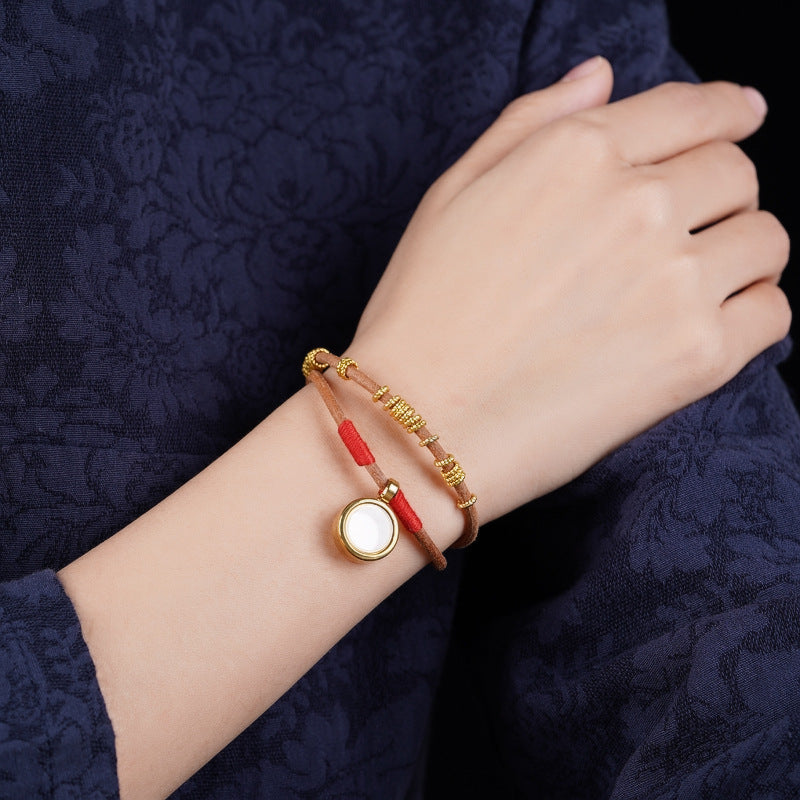 Gau Box Bracelet – worn on wrist with navy floral sleeve, gold locket charm visible, everyday spiritual jewelry